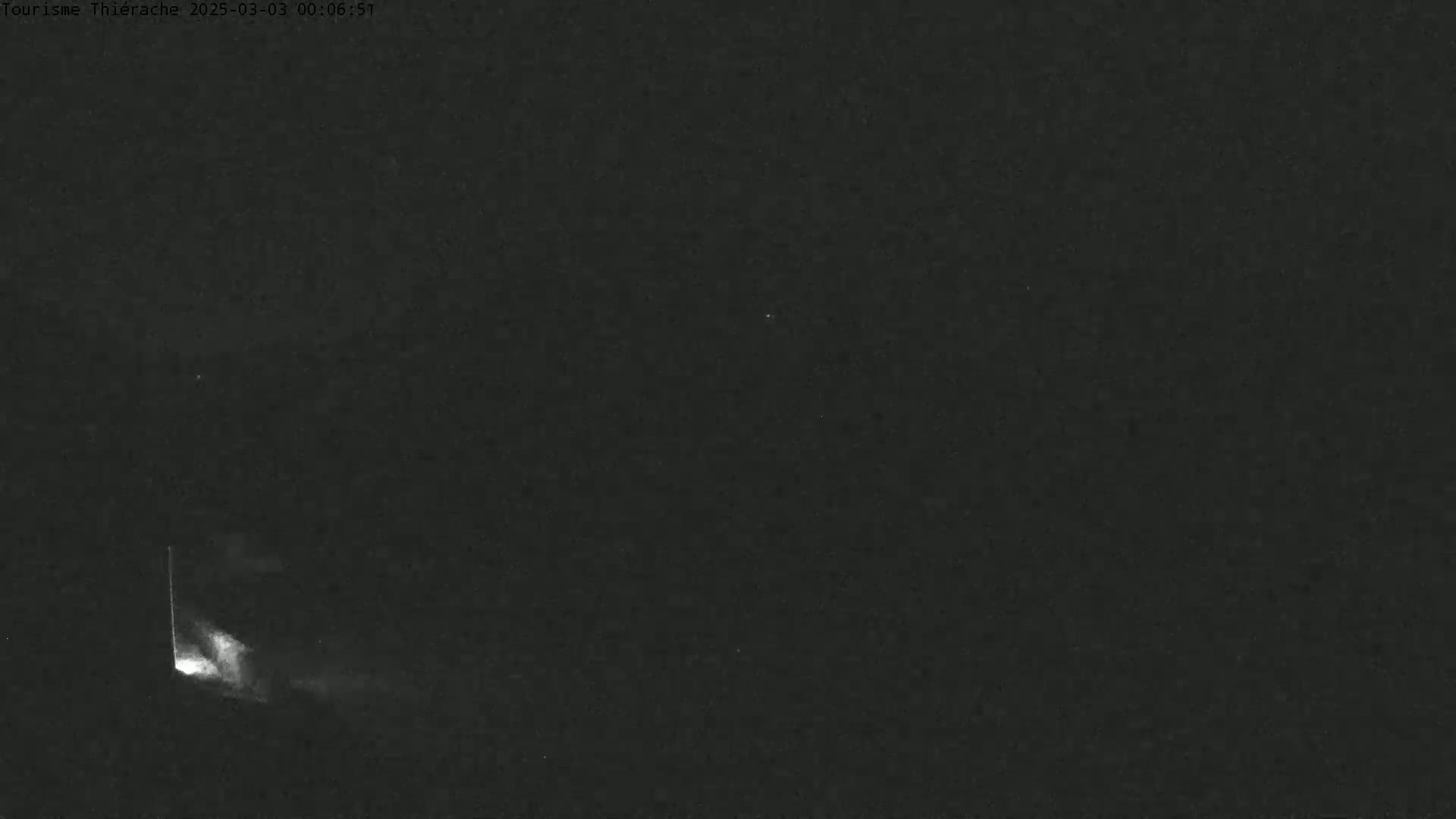 A bright light streaks across a dark, night sky.