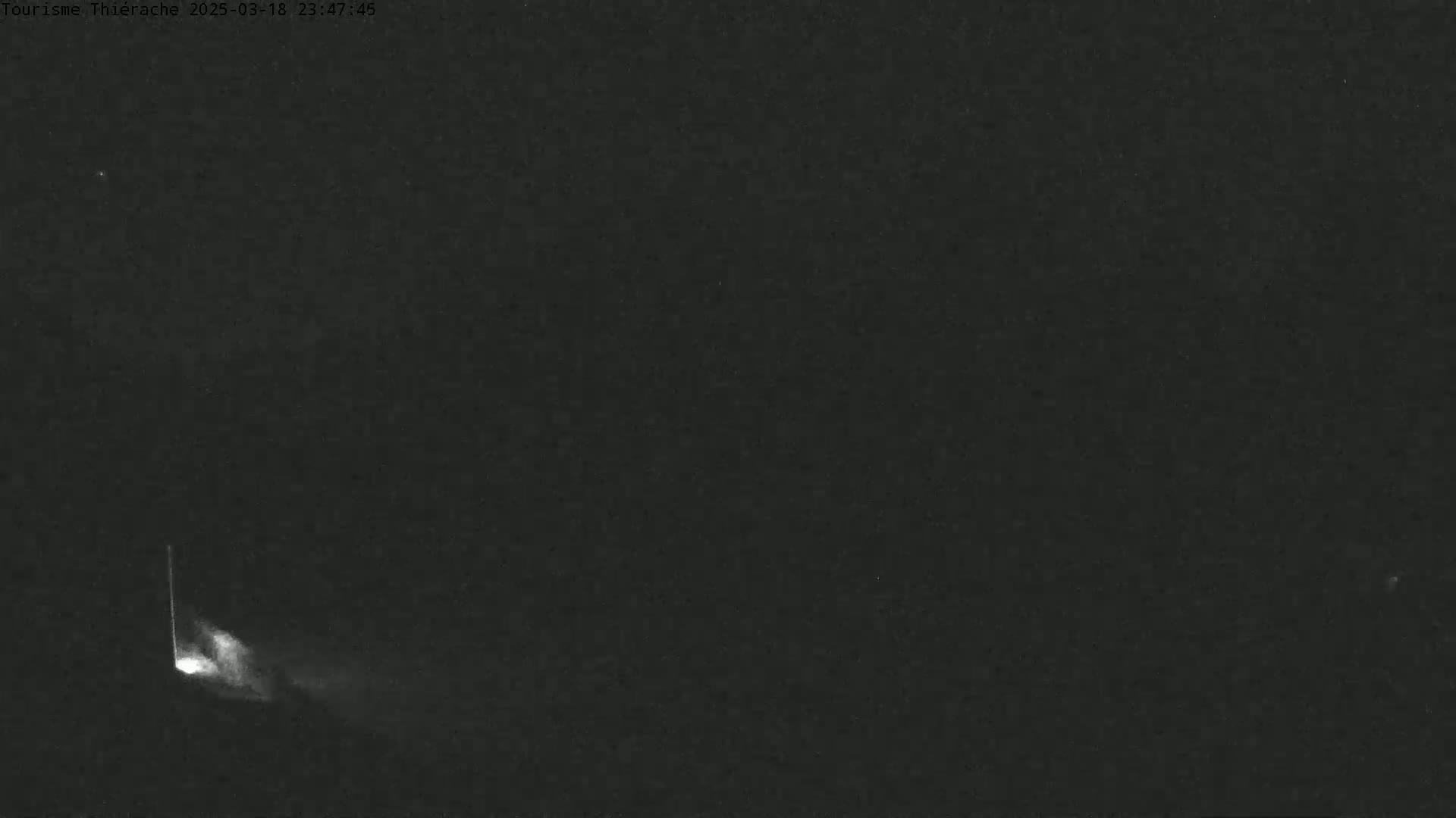 A bright streak of light appears to be a meteor falling across a dark night sky.