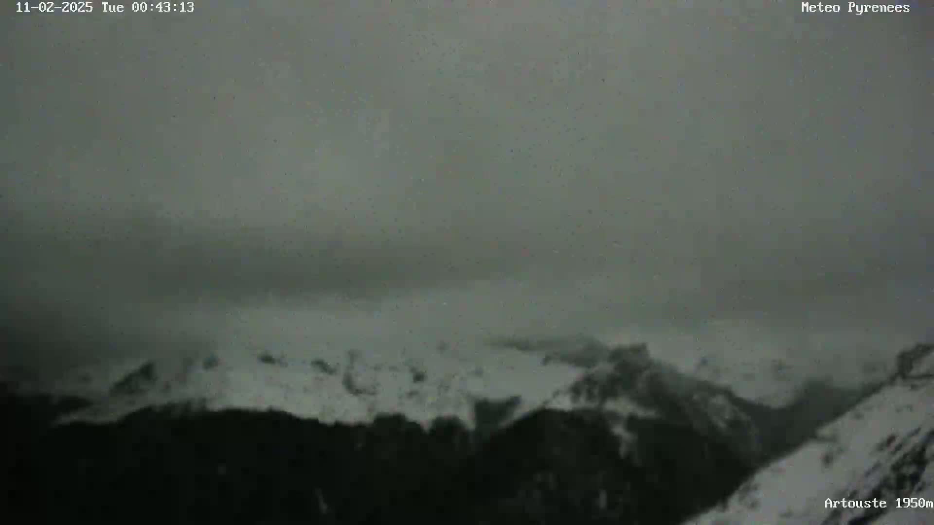 A snow-covered mountain range is visible under a gray, overcast sky.
