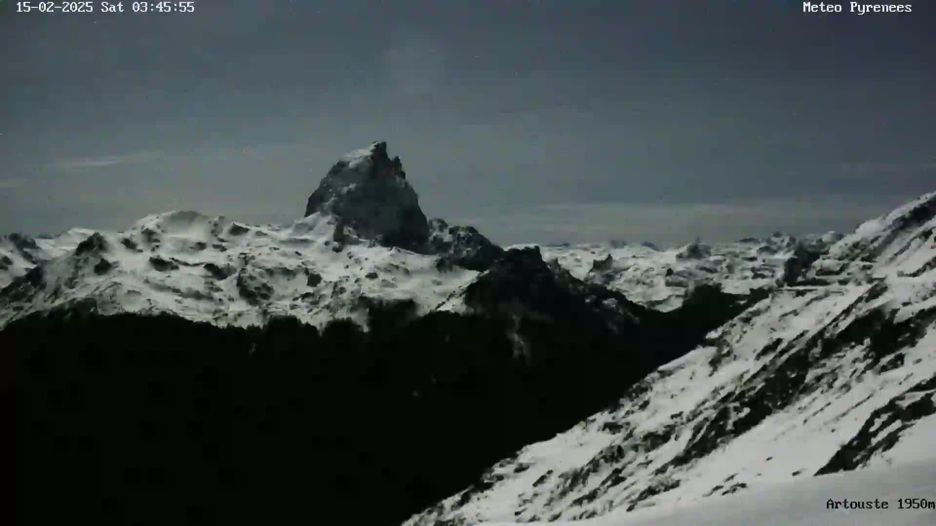 A snow-covered mountain range is visible under a twilight sky.