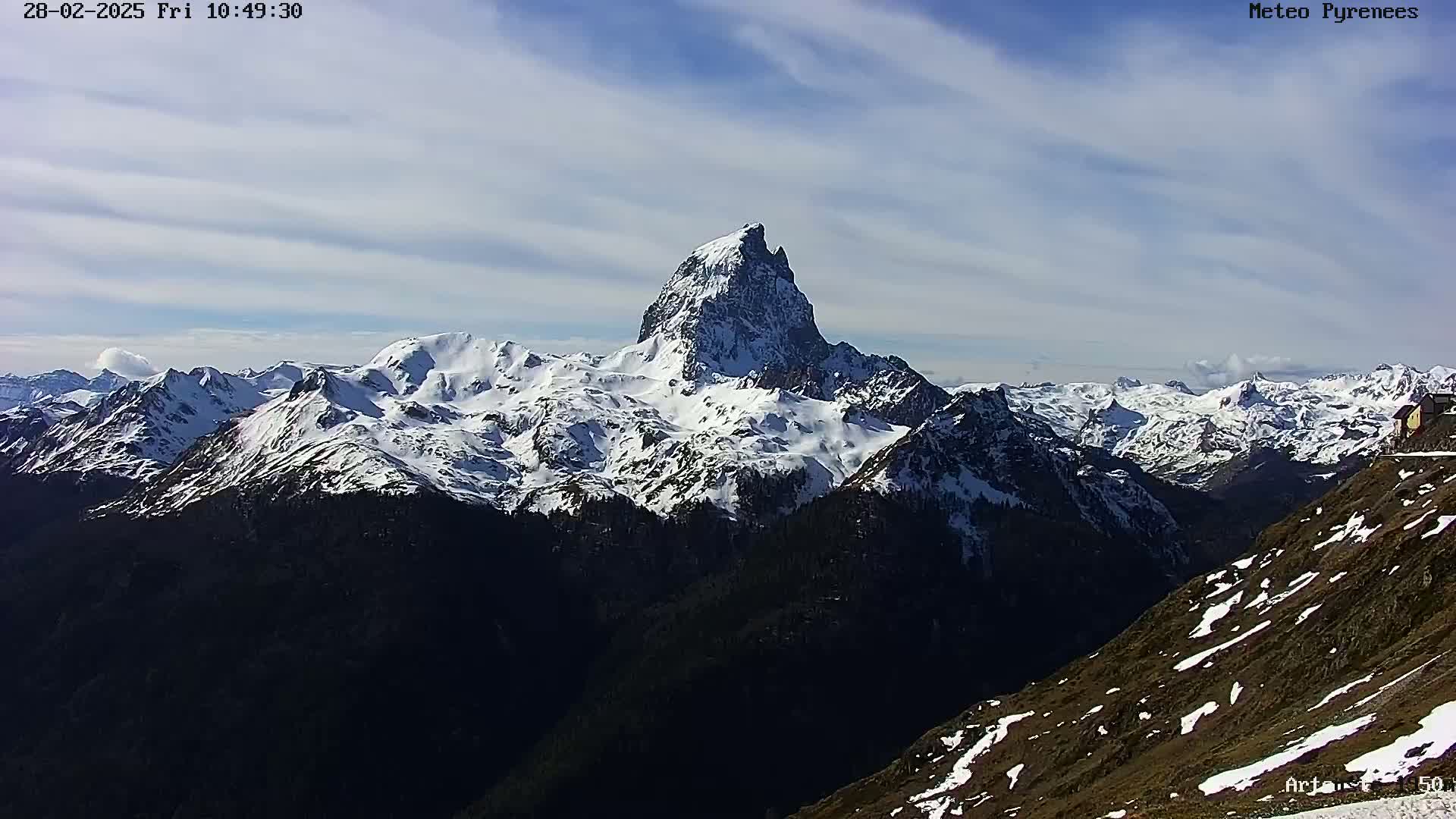 A snow-capped mountain range is visible under a partly cloudy sky.