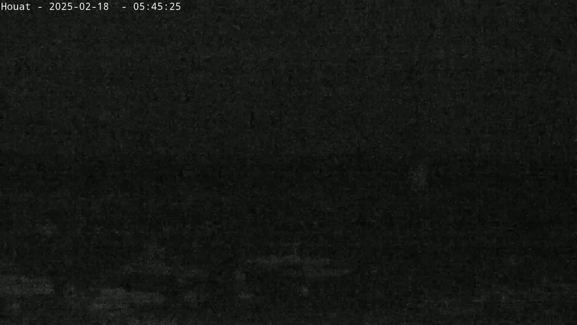 A very dark, grainy image shows a mostly black scene, possibly at night.