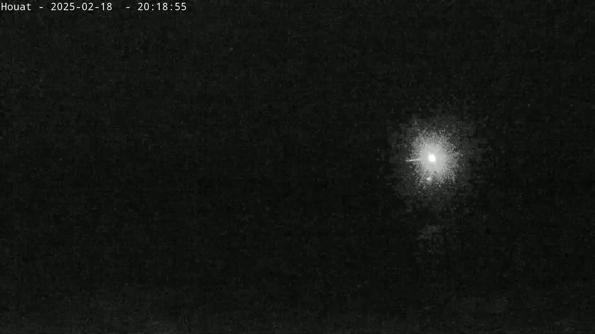 A bright light, possibly a star or planet, is visible in the dark night sky.