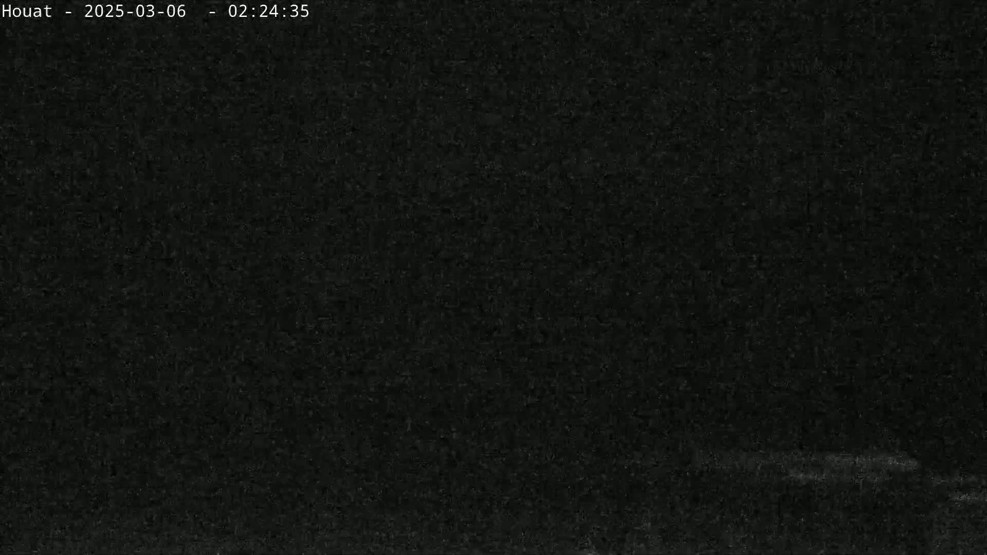 A dark, grainy image shows a mostly black scene with a very faint, lighter horizontal line near the bottom.