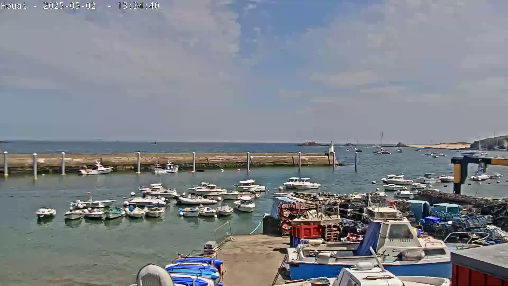 A harbor filled with numerous boats under a partly cloudy sky.