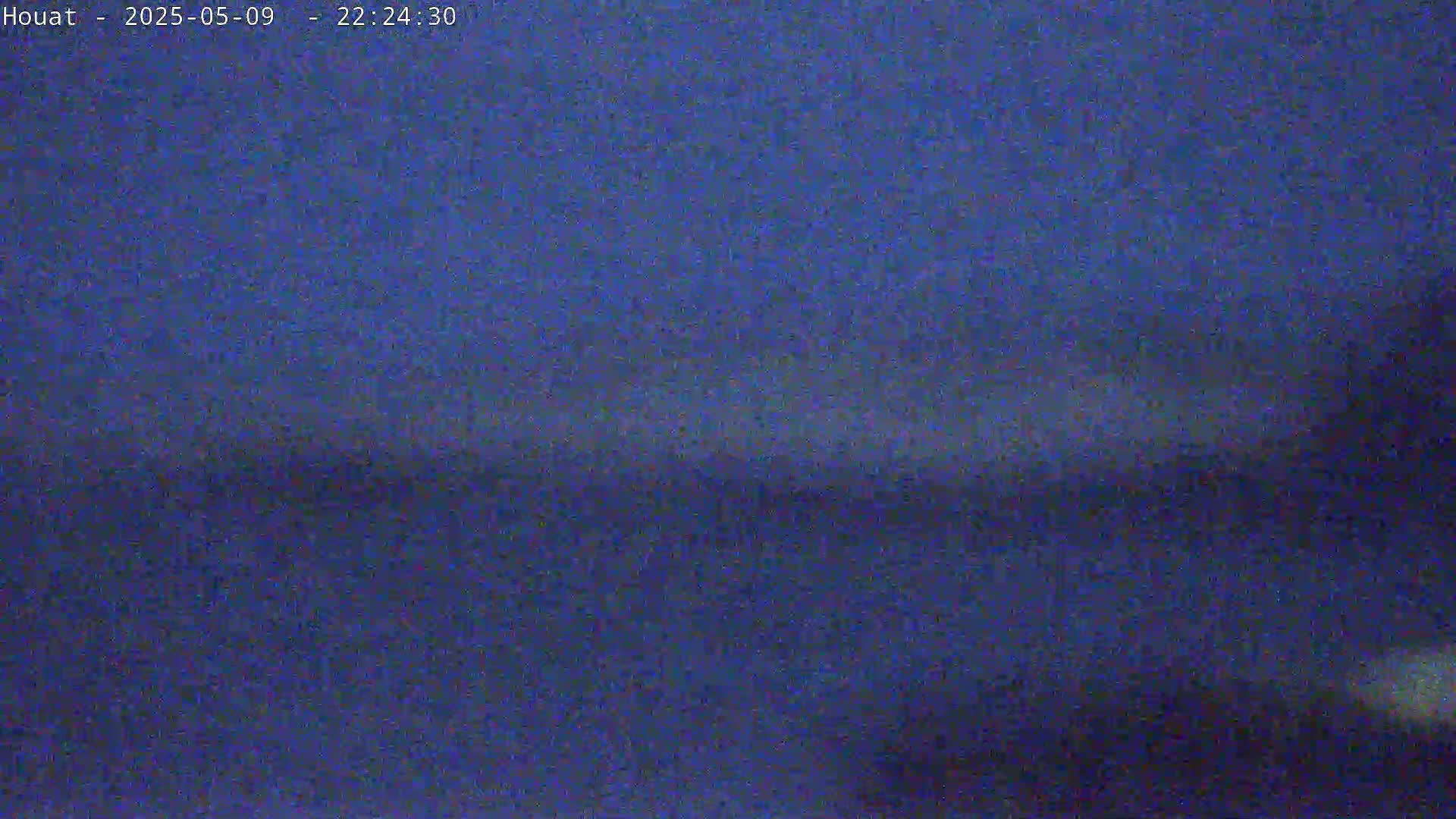 A dark blue, possibly nighttime, outdoor scene shows a blurry, indistinct horizon line.