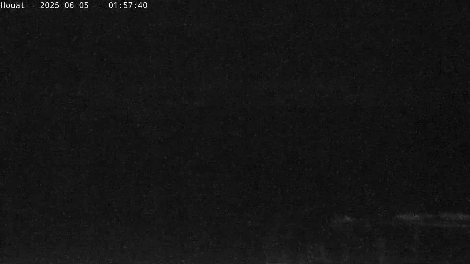 A mostly dark image shows a faint, blurry line at the bottom, suggesting a dark, possibly nighttime scene with low visibility.