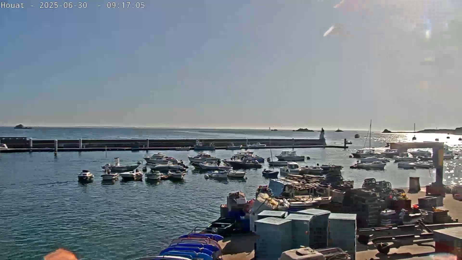 A harbor filled with numerous boats under a bright, sunny sky.