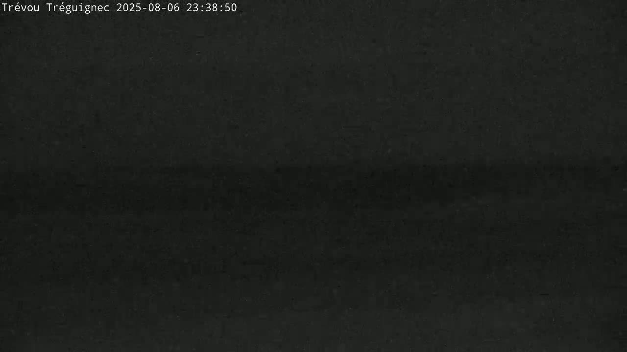 A dark, possibly nighttime image shows a mostly uniform dark gray or black surface with subtle variations in shading.