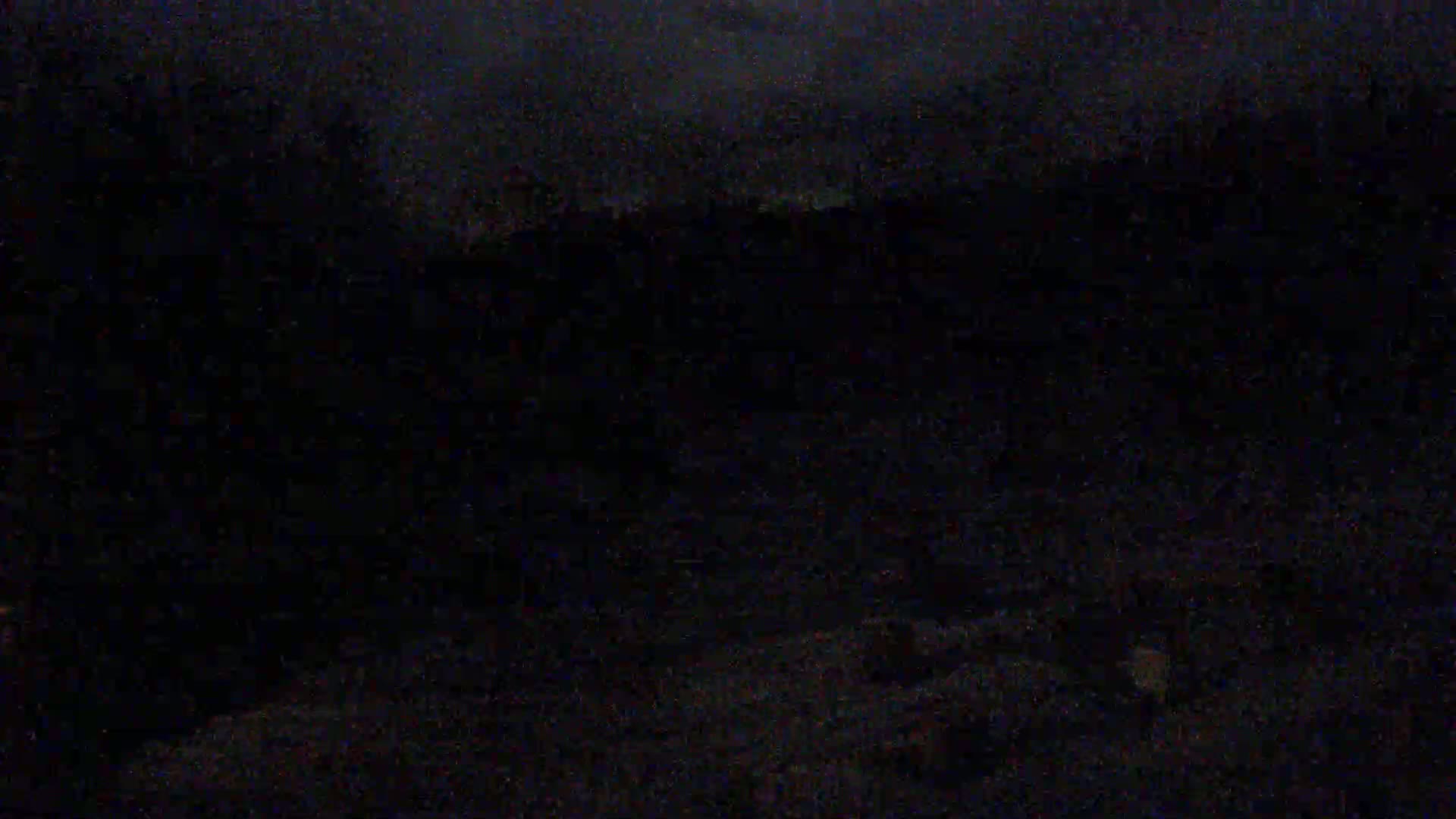 A dark, nighttime scene shows a mostly obscured ground area under a cloudy sky.