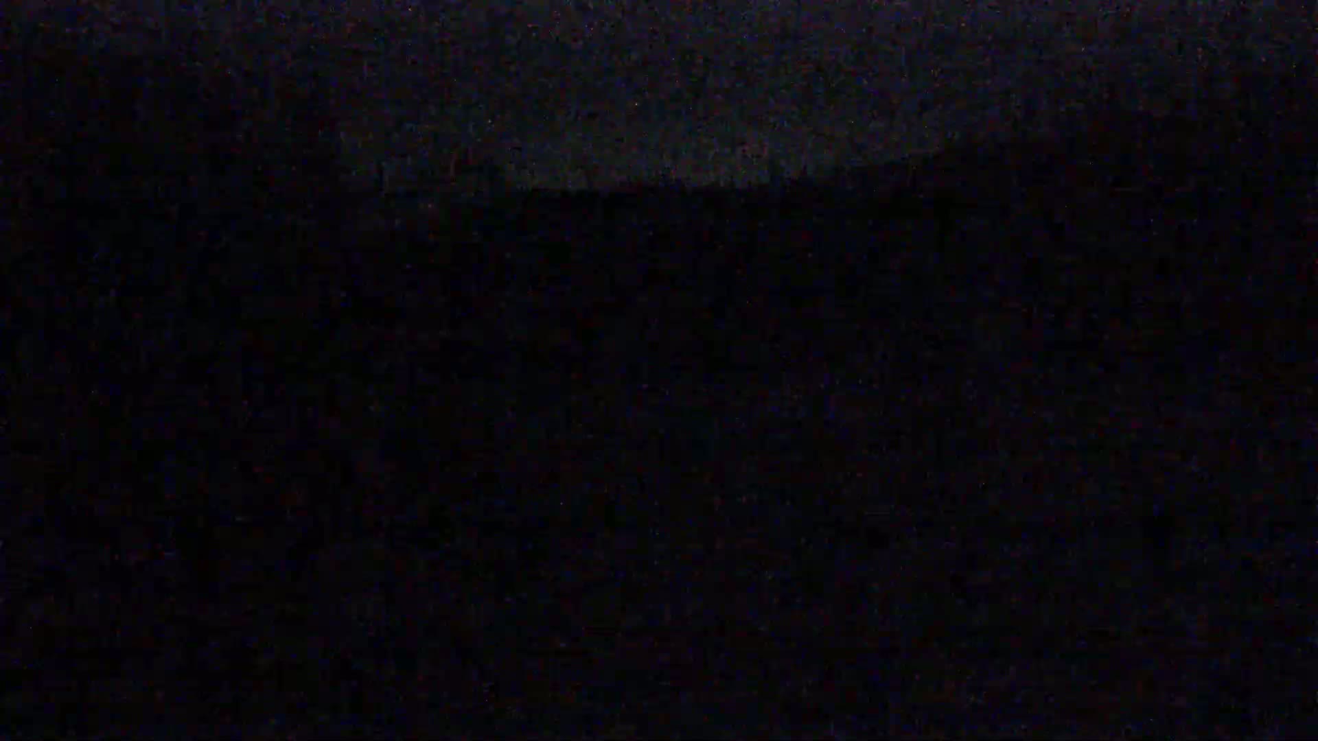A dark, nighttime image shows a barely visible, indistinct horizon line.