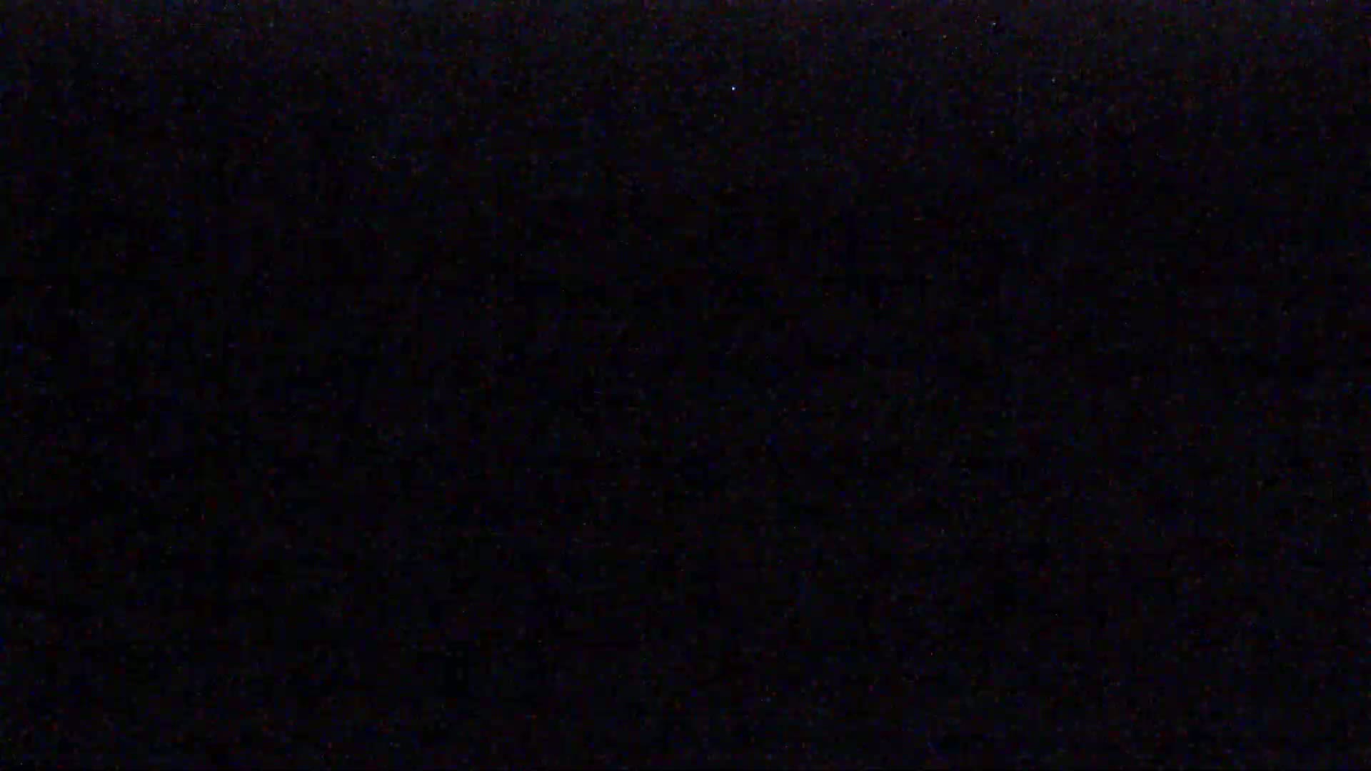 The image is a solid black field with very fine speckles of color.