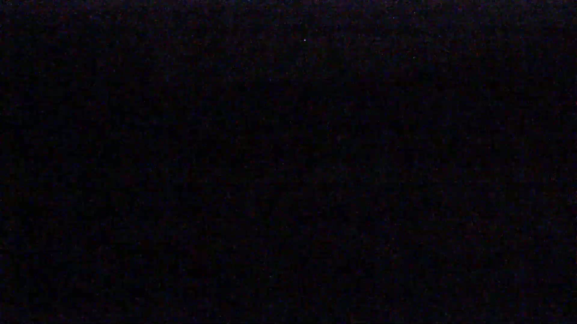 The image shows a completely black field with very faint, barely visible speckles.