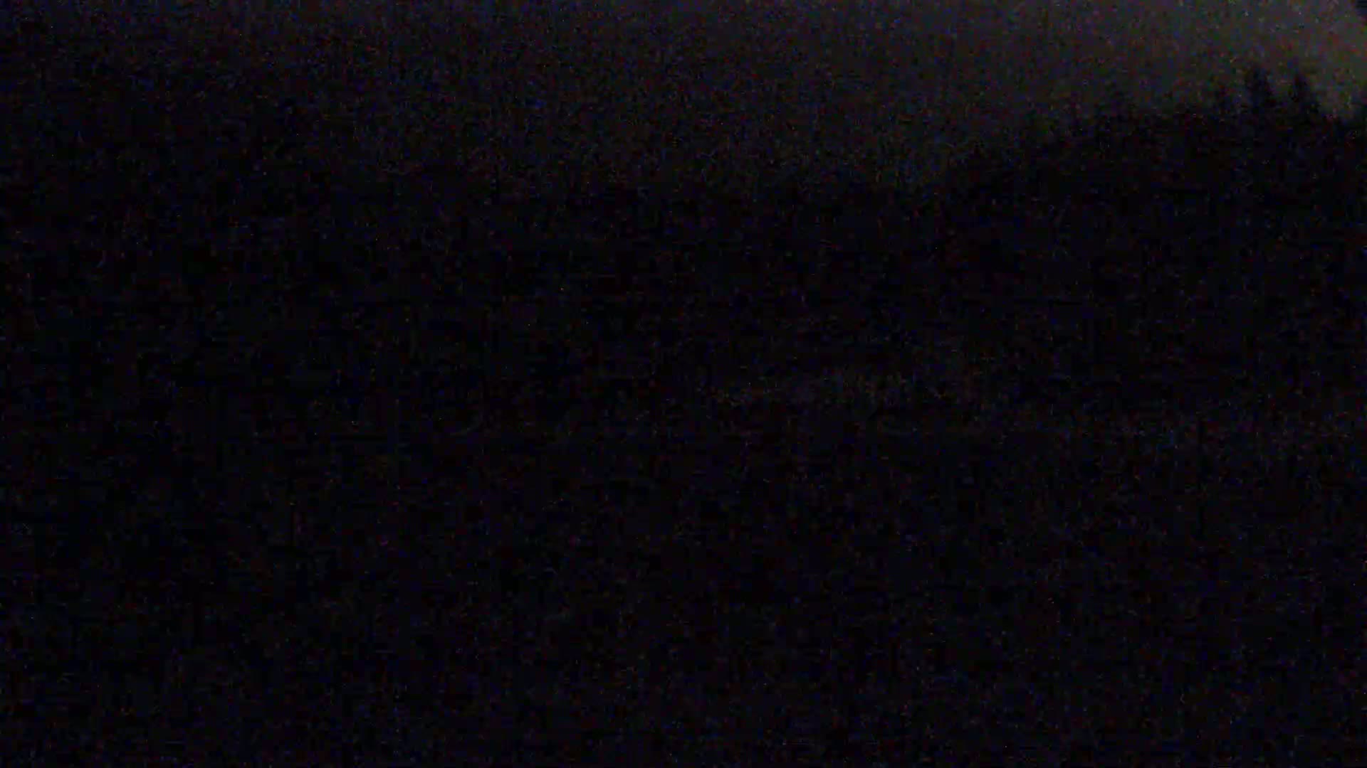 A very dark image shows a mostly obscured landscape at night, possibly under a cloudy sky.