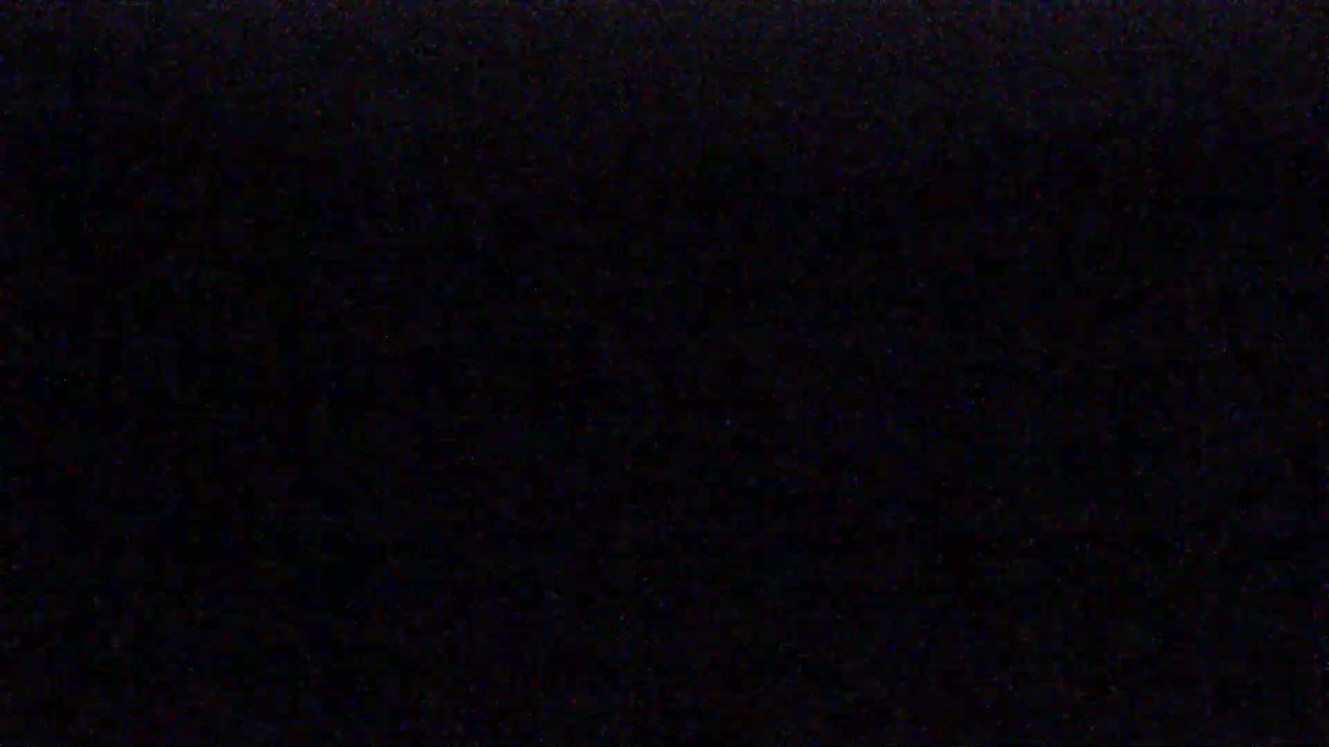 The image is a completely black screen with some very faint speckles of color.