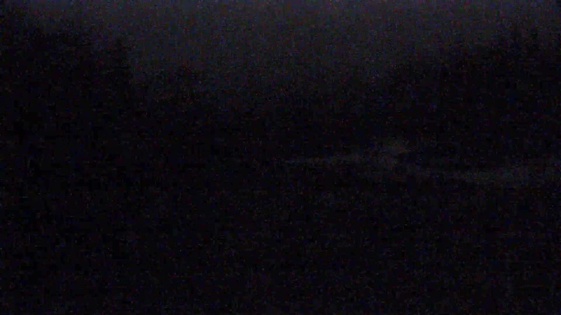 The image is an extremely dark, blurry shot of what appears to be a nighttime outdoor scene with a low-light, possibly foggy or hazy condition.