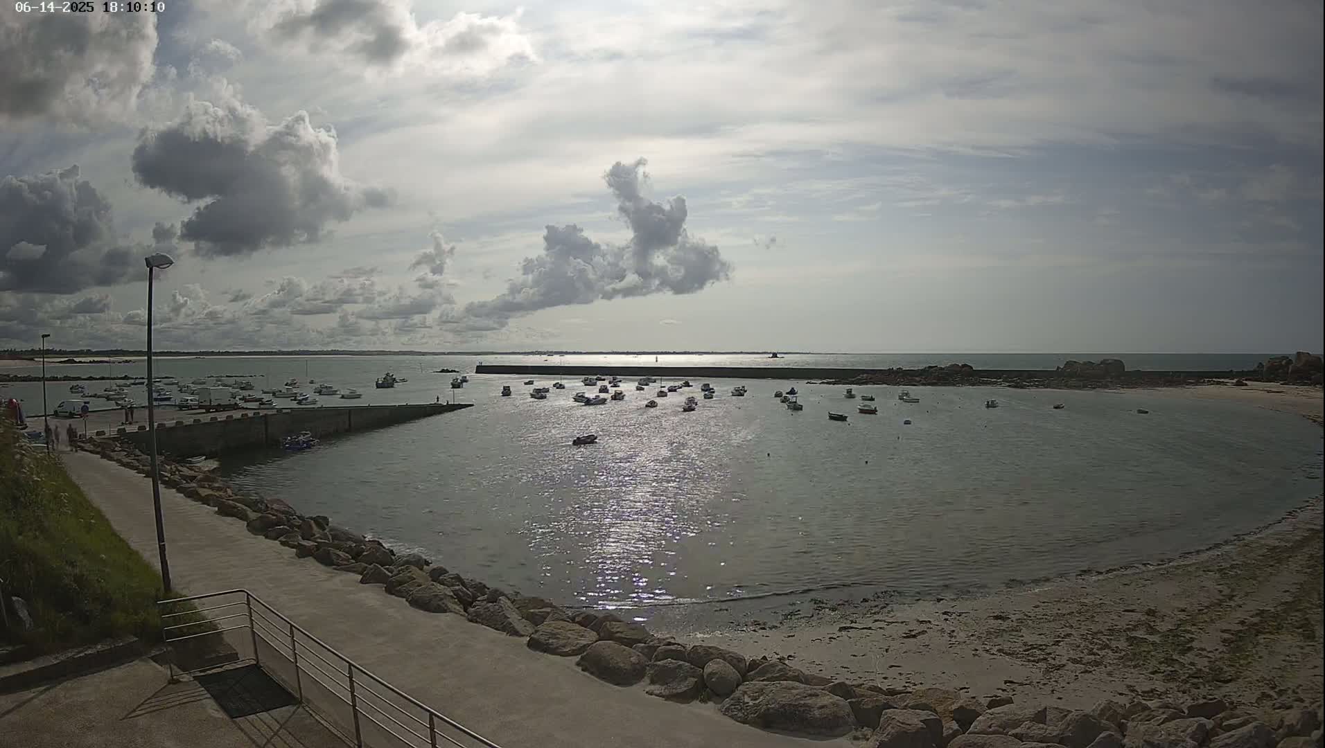 A harbor filled with small boats under a partly cloudy sky.