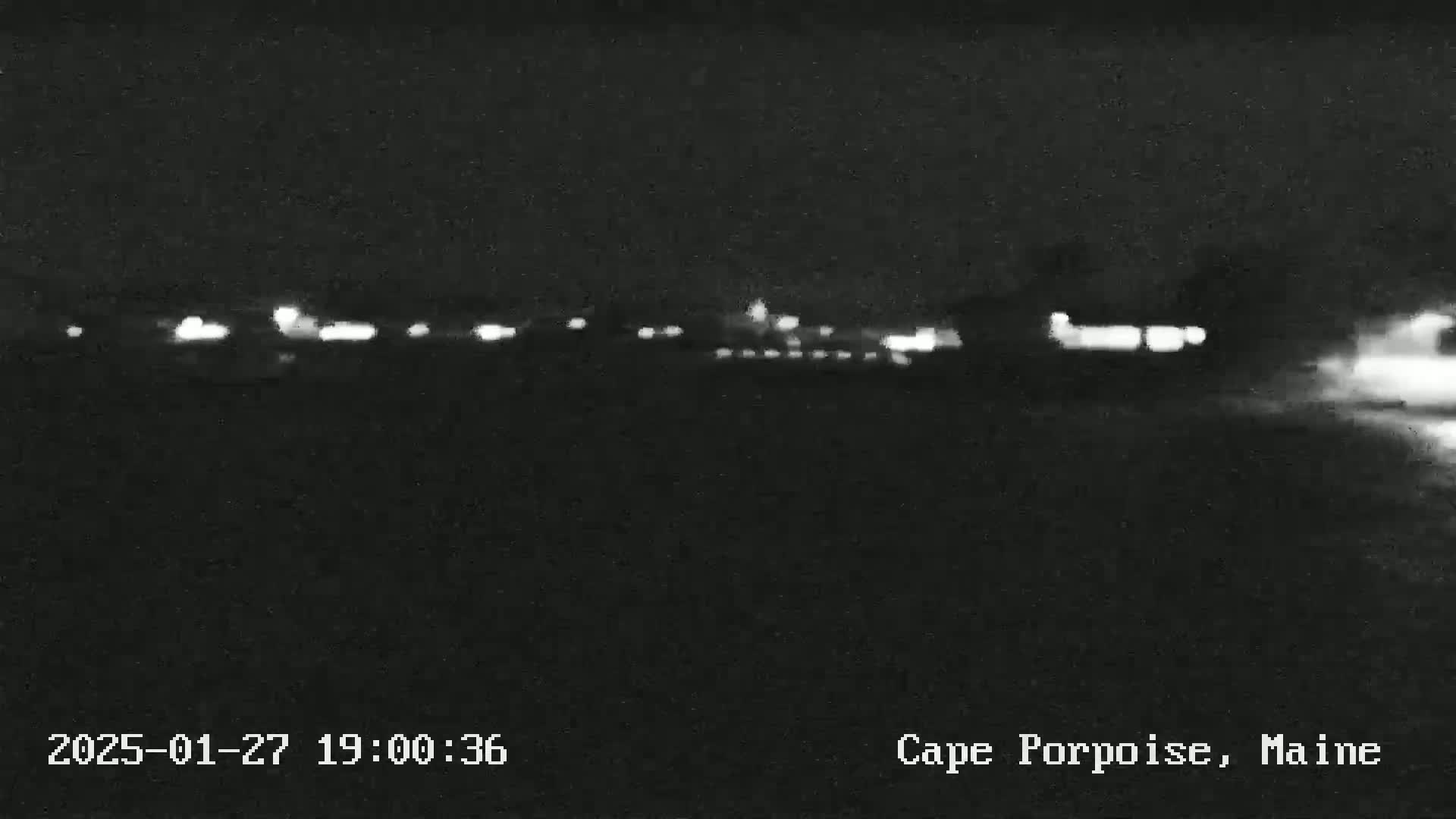 A nighttime, low-light view of a distant line of lights, possibly a town or buildings.