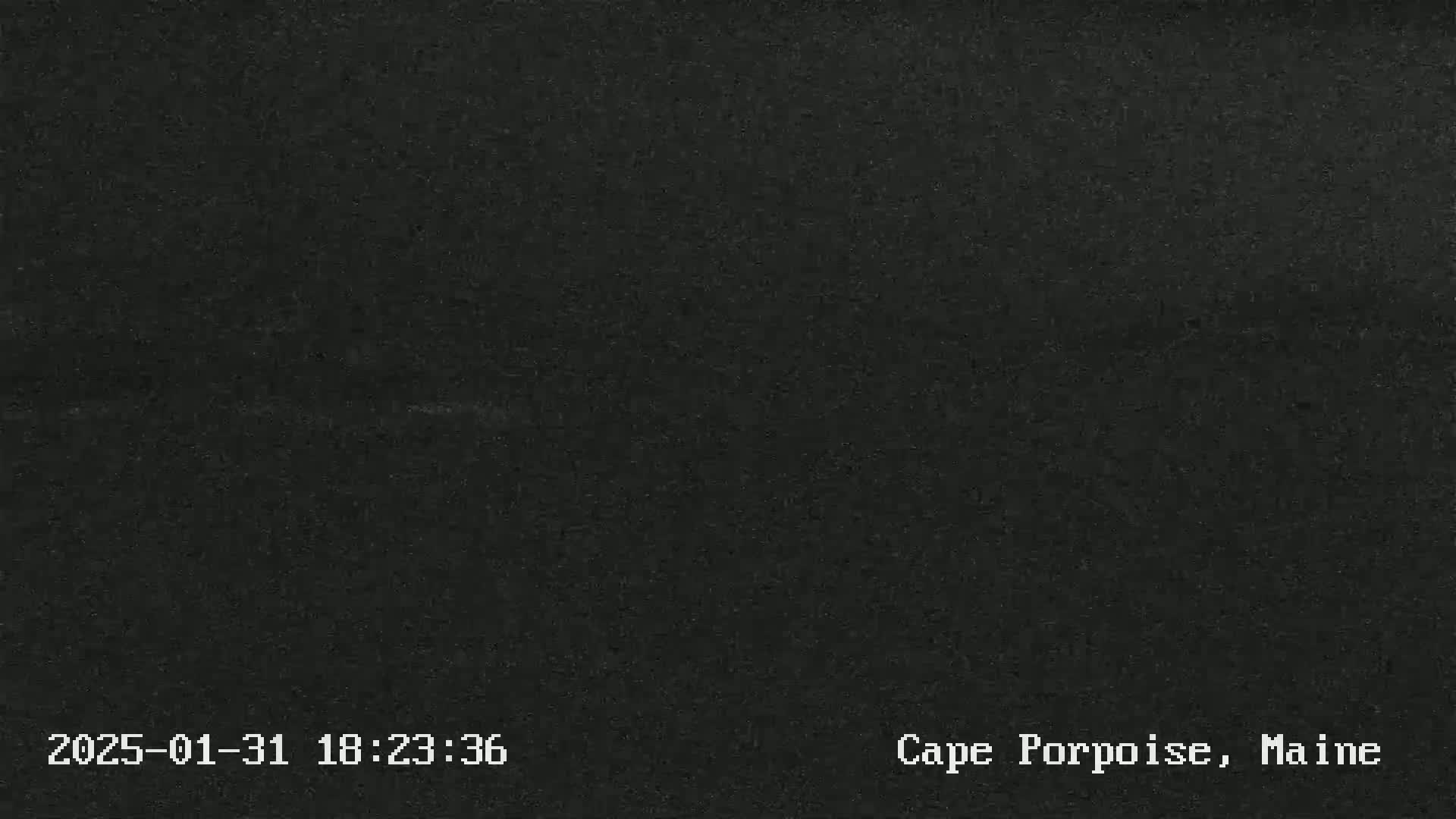 A dark, possibly nighttime image shows a uniformly dark gray or black surface.