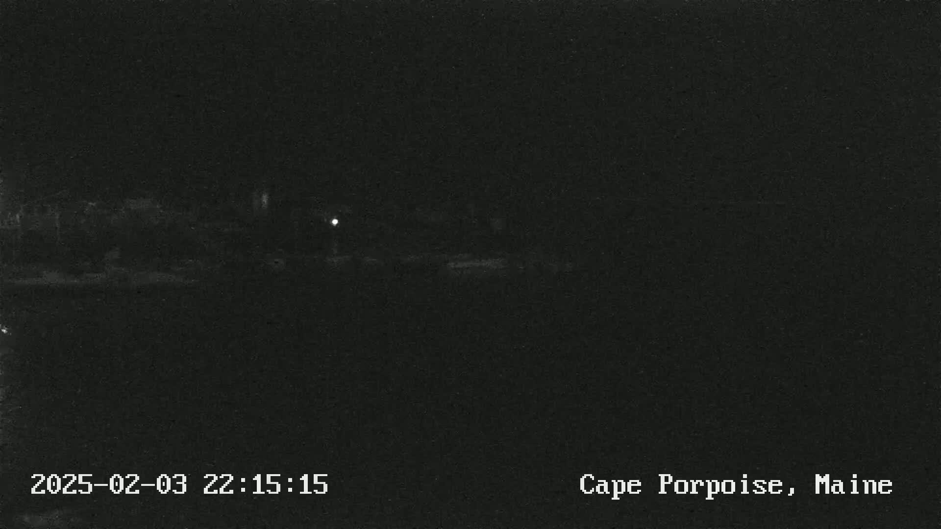 A dark, nighttime scene shows a dimly lit landscape under a clear sky.
