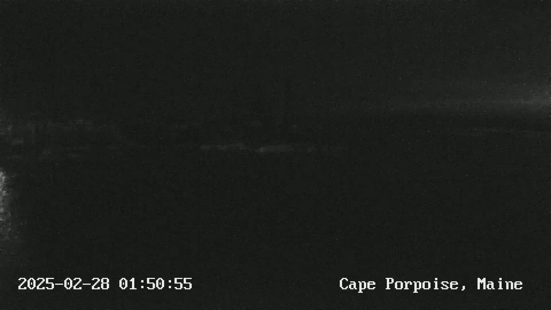 A dark, nighttime image shows a mostly featureless horizon line under a clear sky.