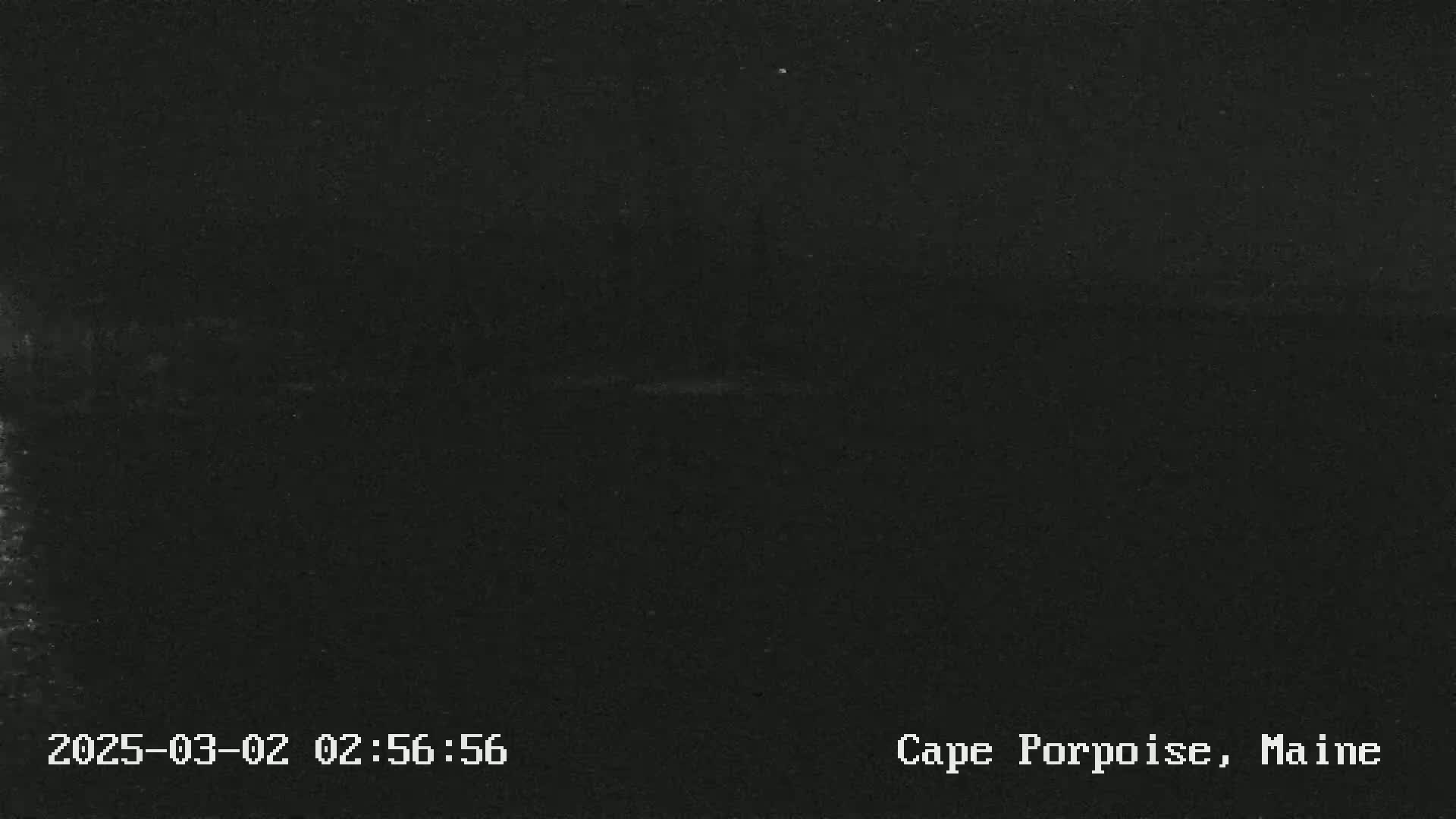 A dark image shows a mostly black nighttime scene with a faint, barely visible horizon line.