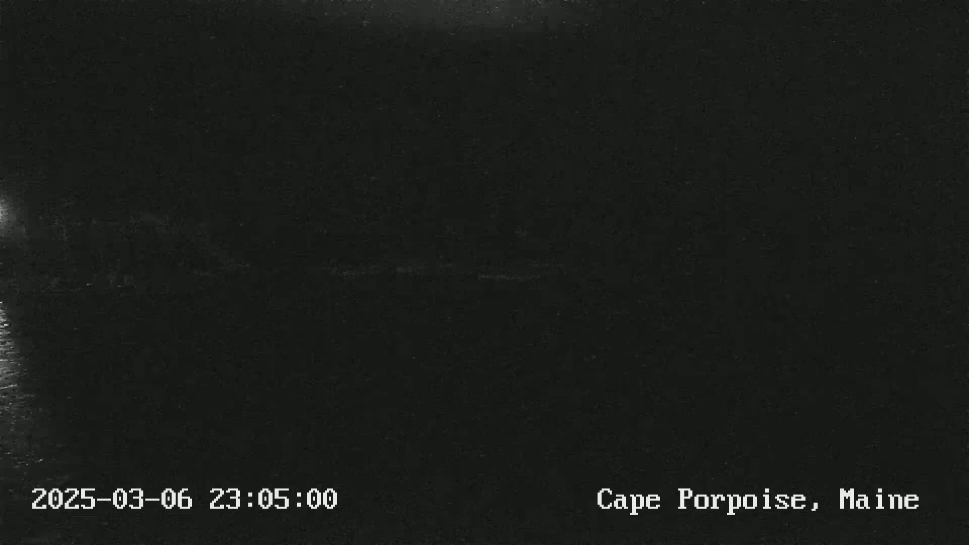 A dark, nighttime image shows a very poorly lit, indistinct scene.