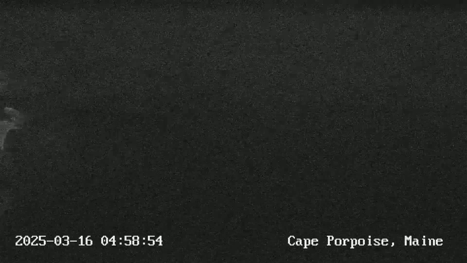 A dark, grainy image shows an overcast night.