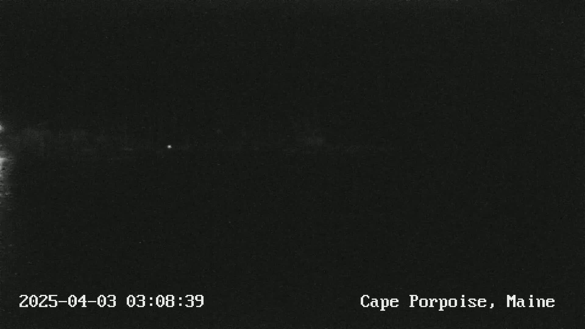 A nighttime, low-light image shows a dark, mostly featureless scene.