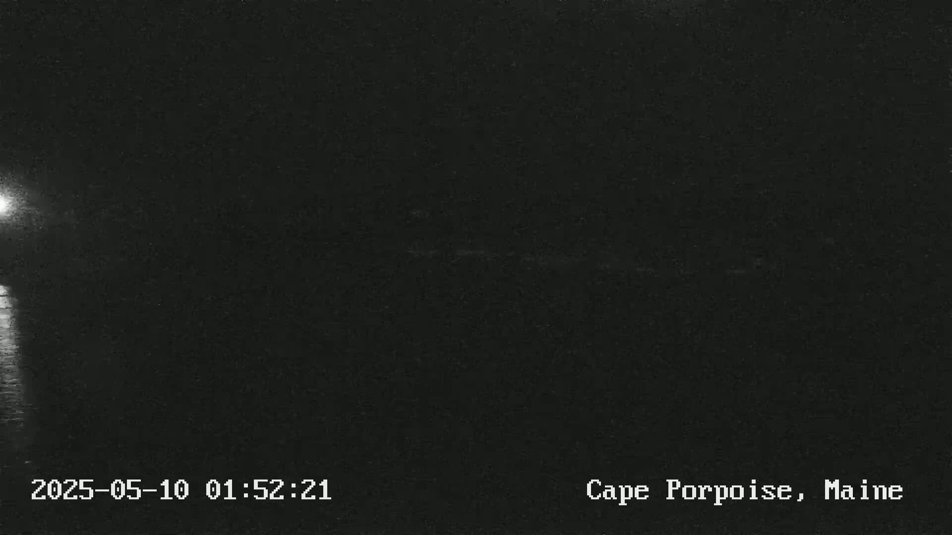 A dark, nighttime image shows a dimly lit body of water.