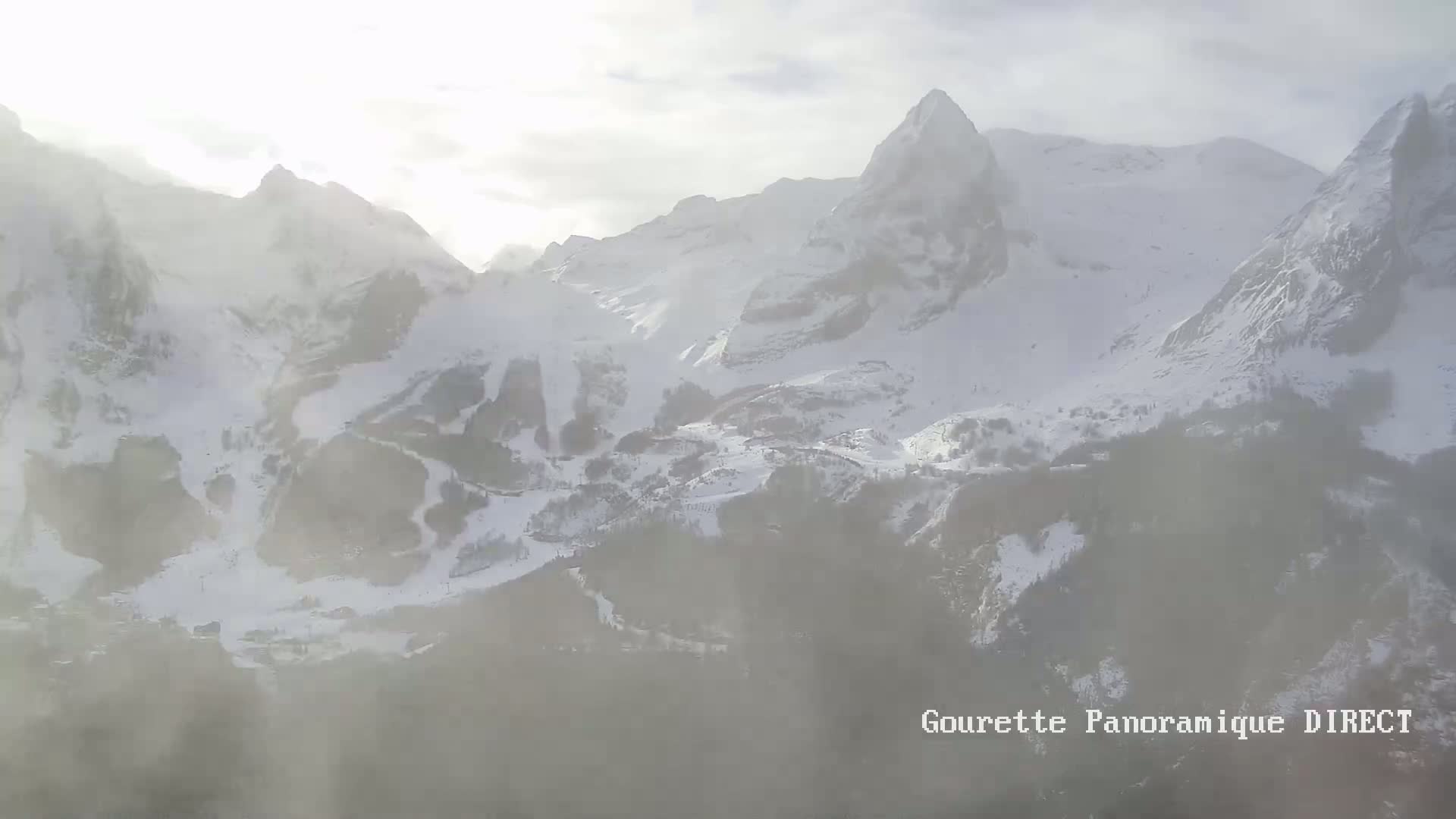 A hazy, snowy mountain range is partially obscured by fog or mist.