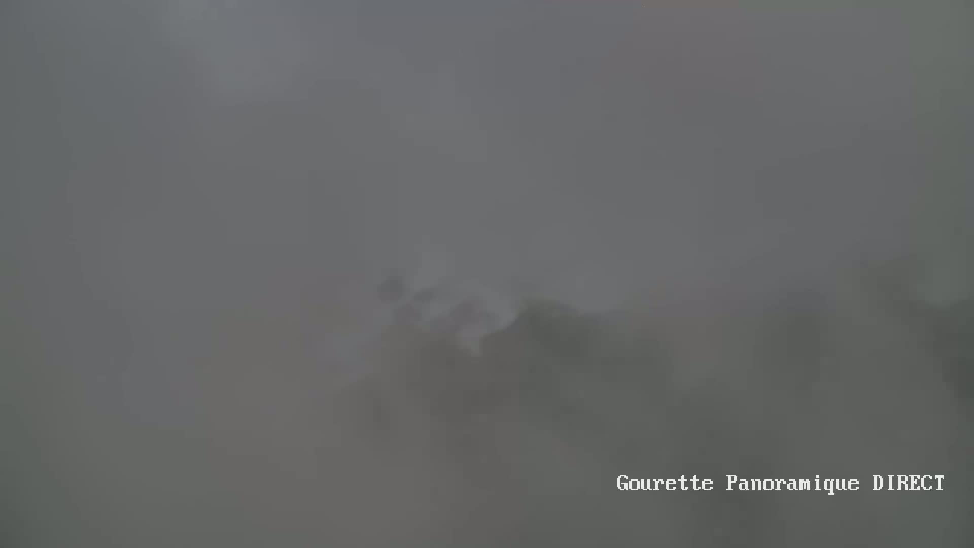 A blurry, indistinct view of a landscape shrouded in thick fog.