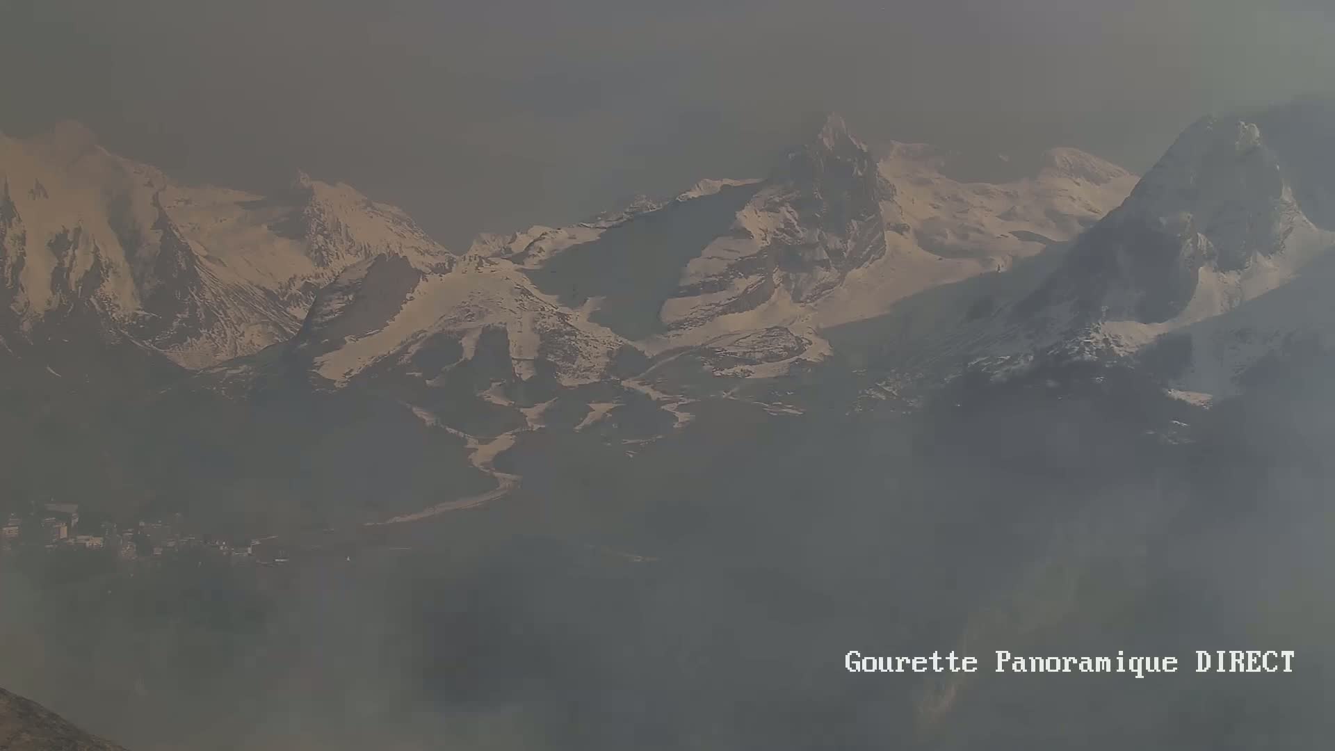 A hazy, distant view of snow-capped mountains.