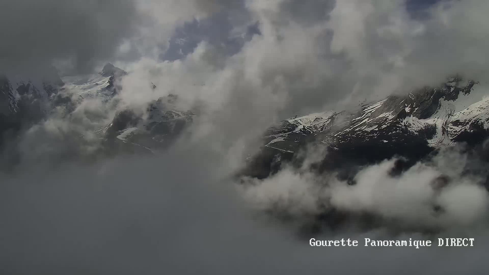 Snow-capped mountains are partially obscured by a thick layer of fog or clouds.