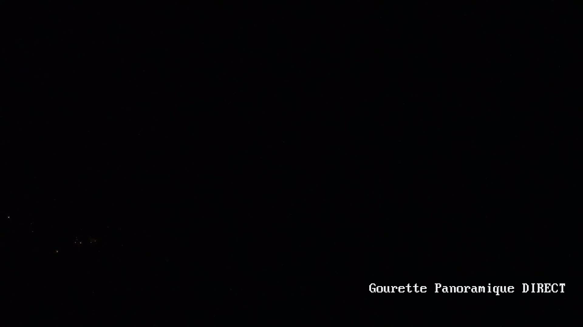 A nighttime, long-range view shows a few distant lights in the darkness.