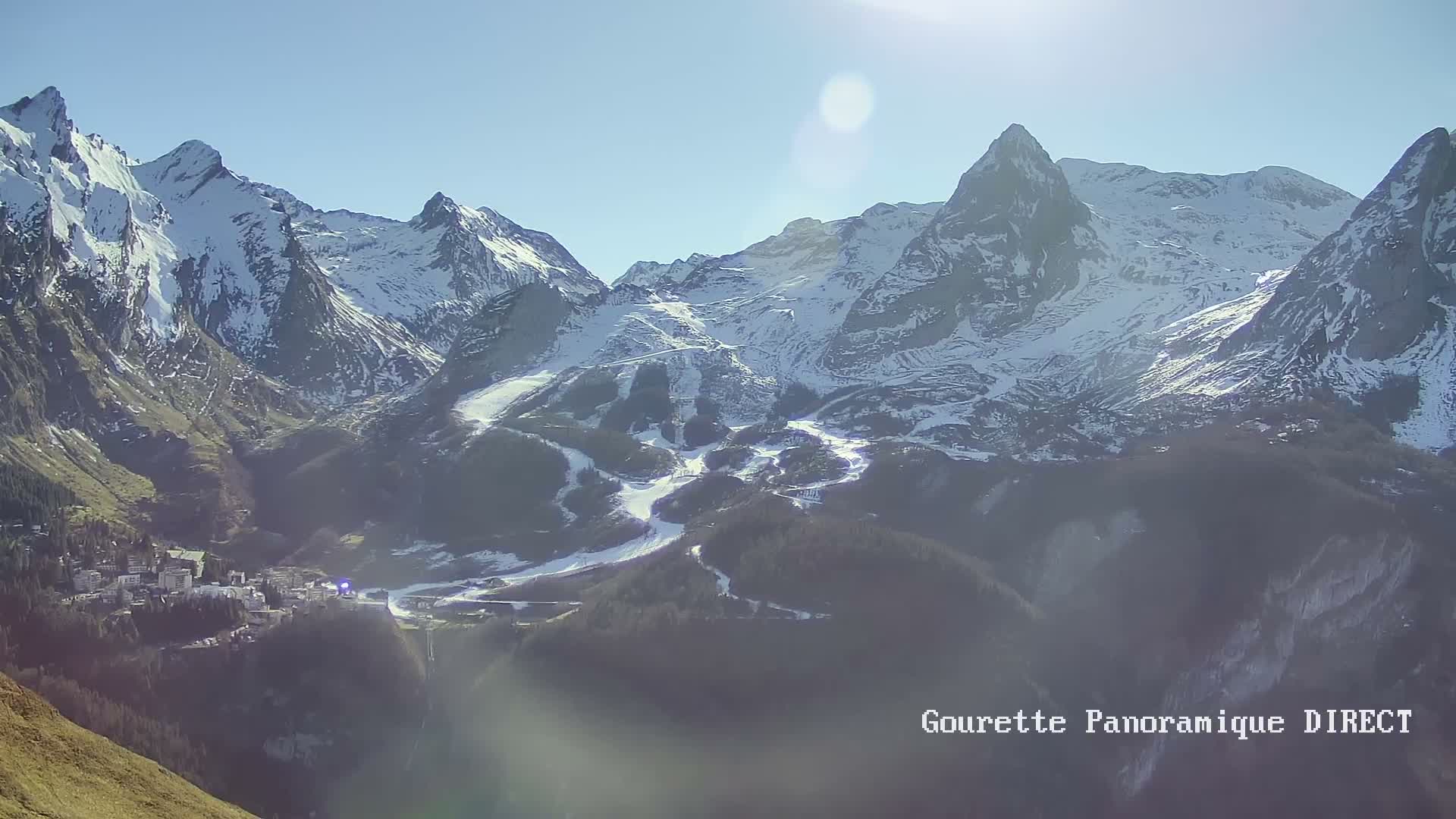 A long-range view shows a mountain range under a clear, light-blue sky.