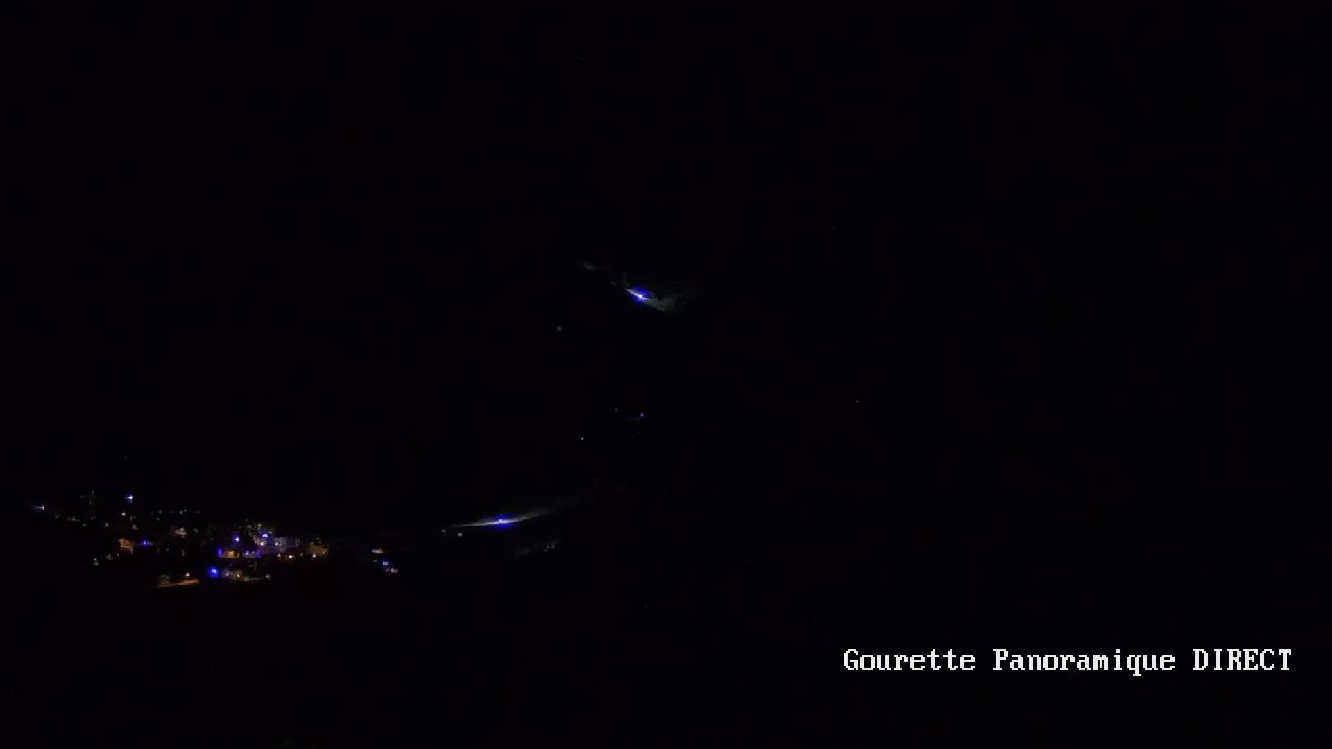 A long-range view shows a mountain range under a clear, light-blue sky.