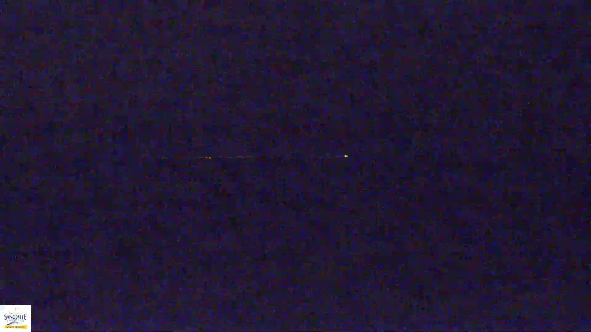 A dark, possibly nighttime, image shows a faint, horizontal line of light across the center with a small, brighter point of light near the middle-right.