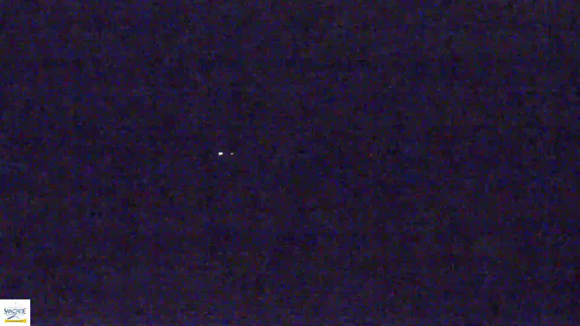 A dark, possibly nighttime, sky shows two small, bright lights.