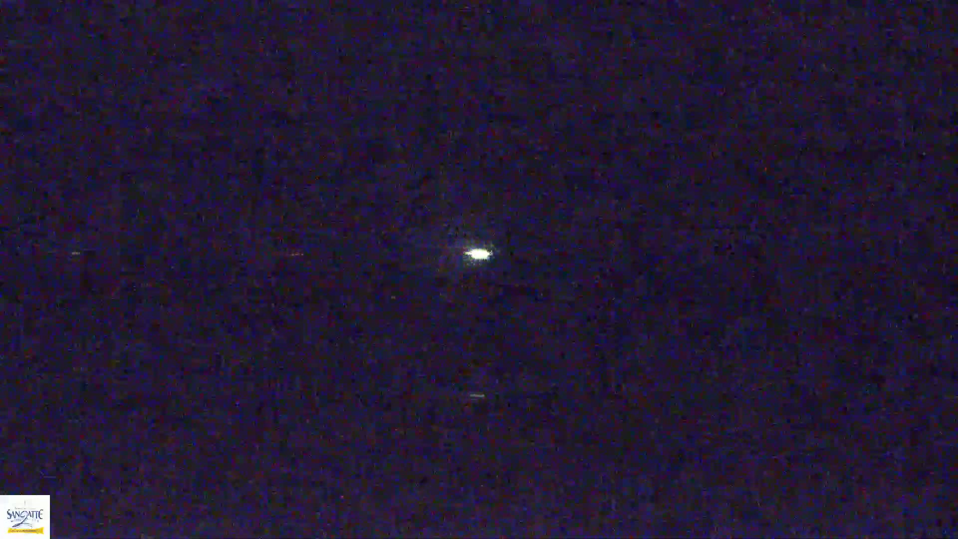 A bright light is visible in the dark night sky.