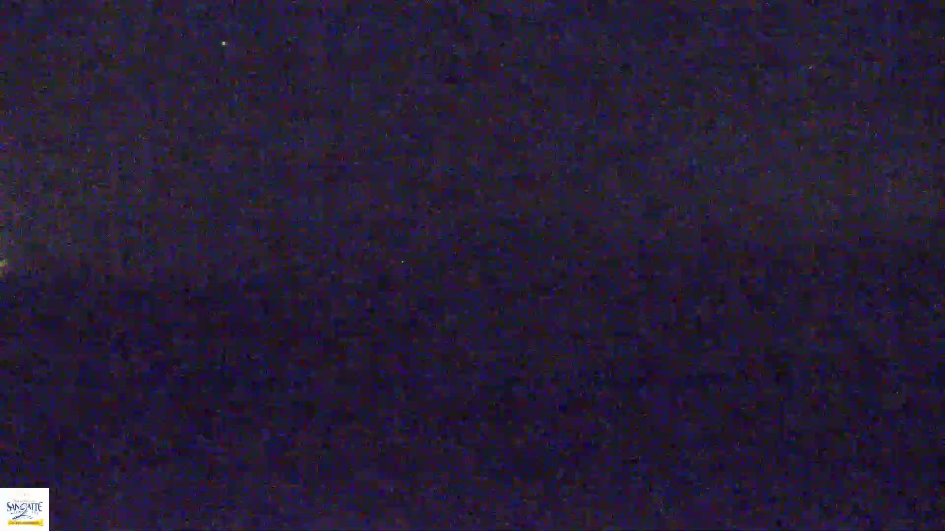A nighttime outdoor image shows a dark, textured sky with a few faint stars.