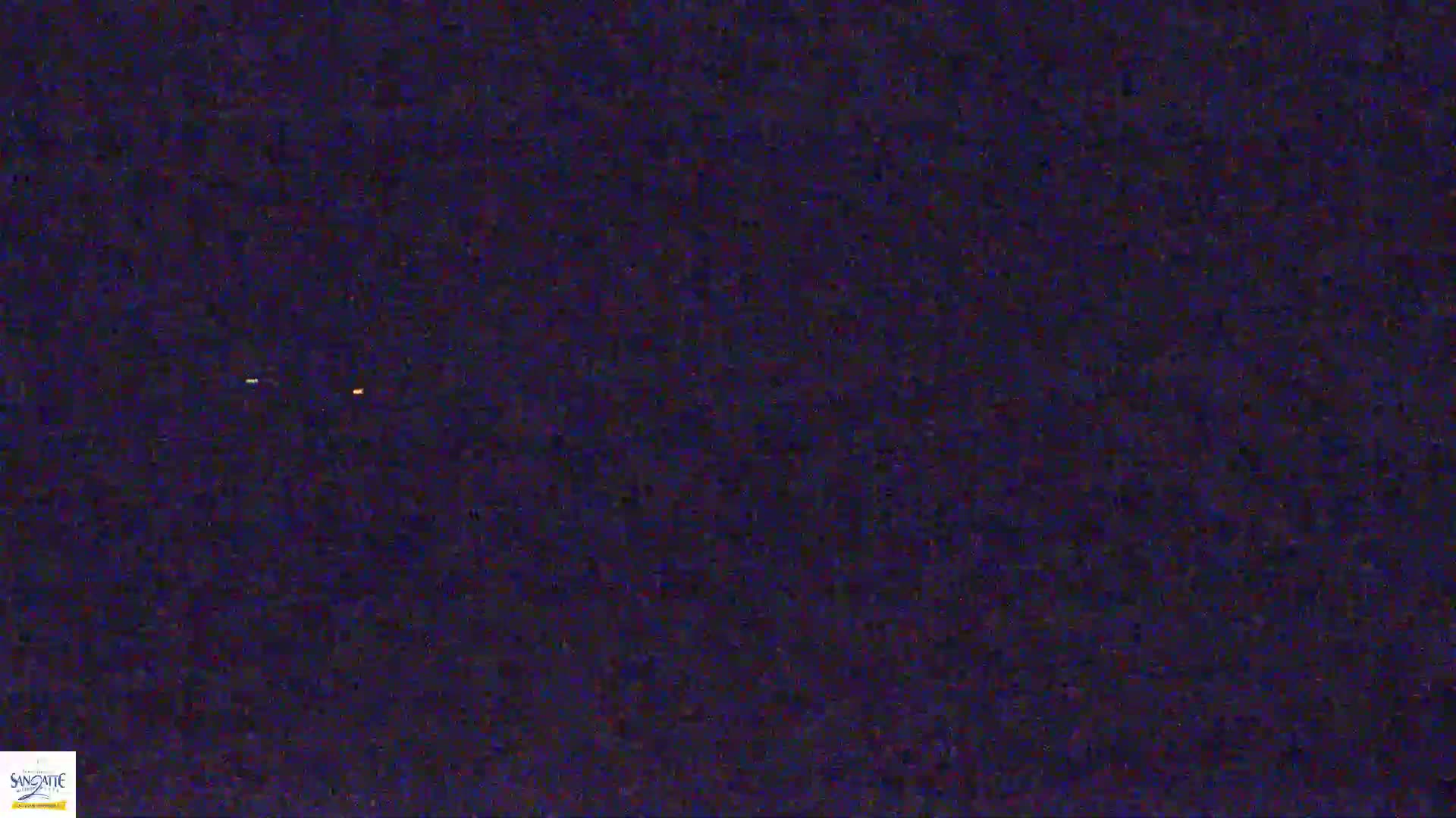 A dark, nighttime scene shows two faint, distant lights in a mostly dark sky.
