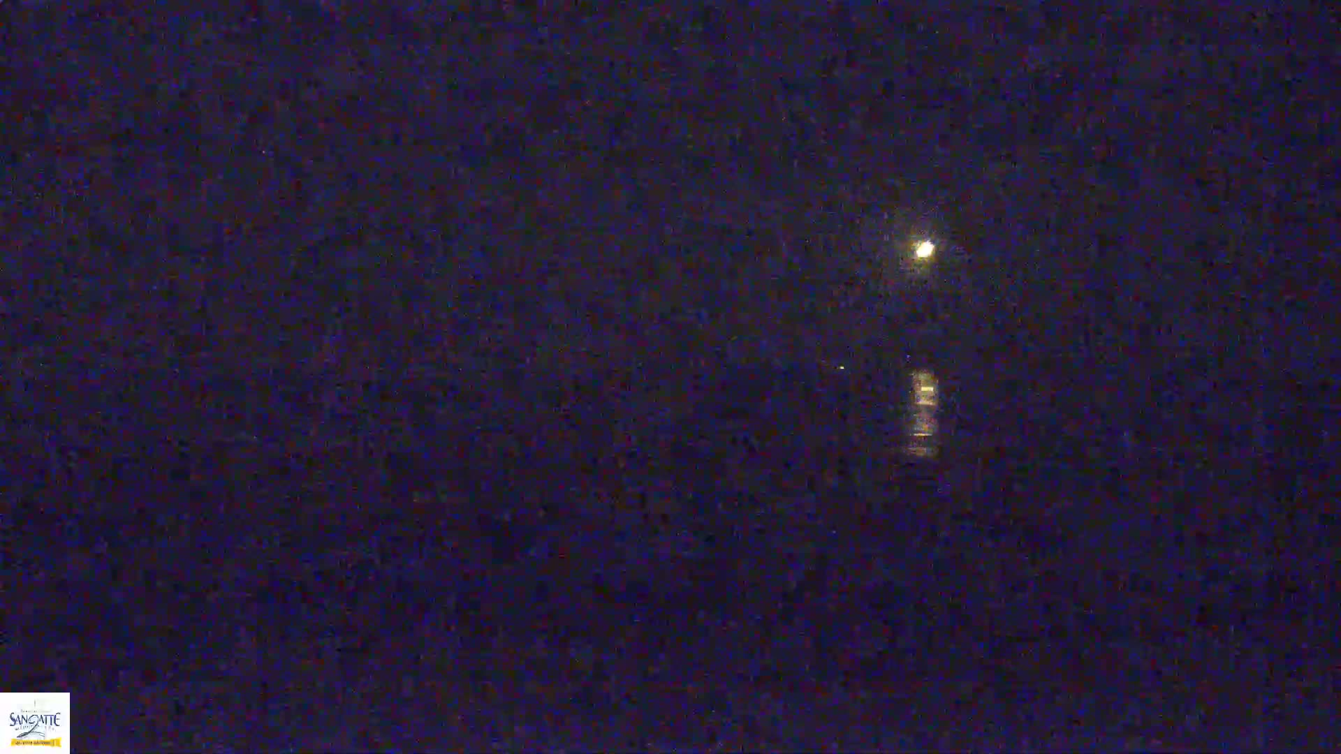 A bright moon illuminates a dark body of water at night.