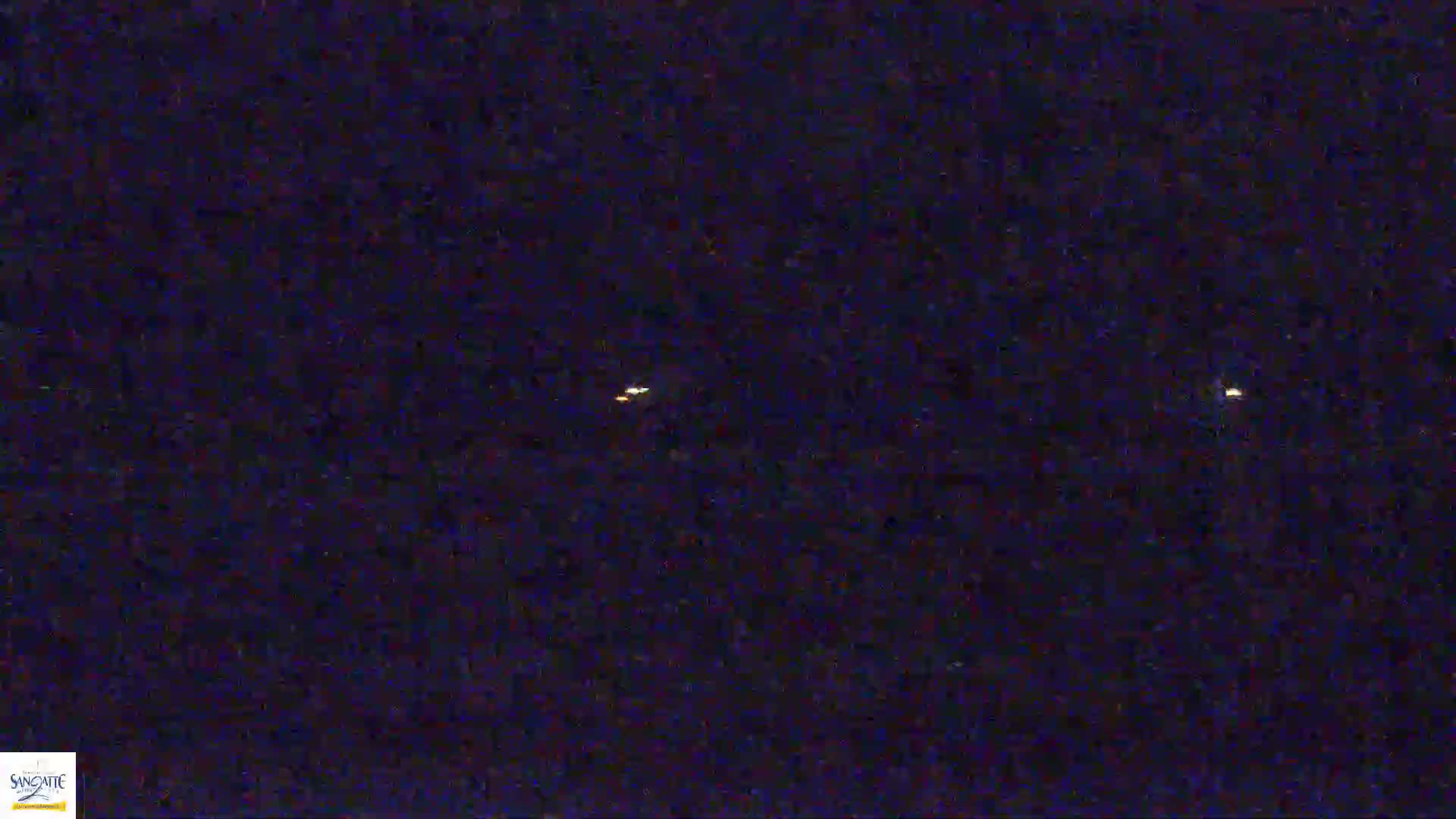 Three small, faint lights are visible in a dark, nighttime sky.
