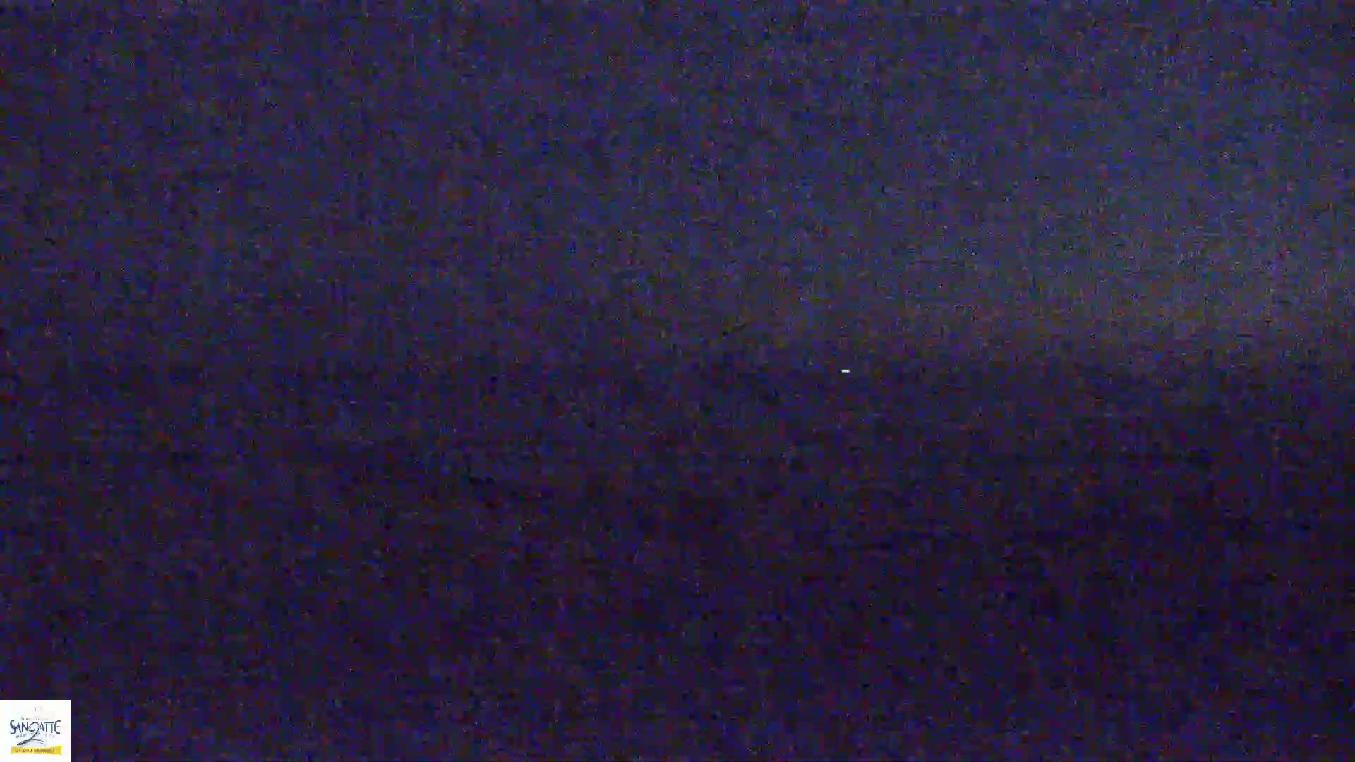 A dark, nighttime scene shows a blurry, possibly wavy, expanse of dark blue.