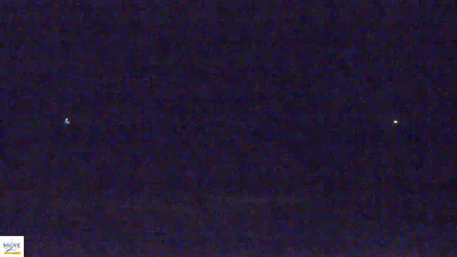 A dark, nighttime sky shows two faint, distant lights.