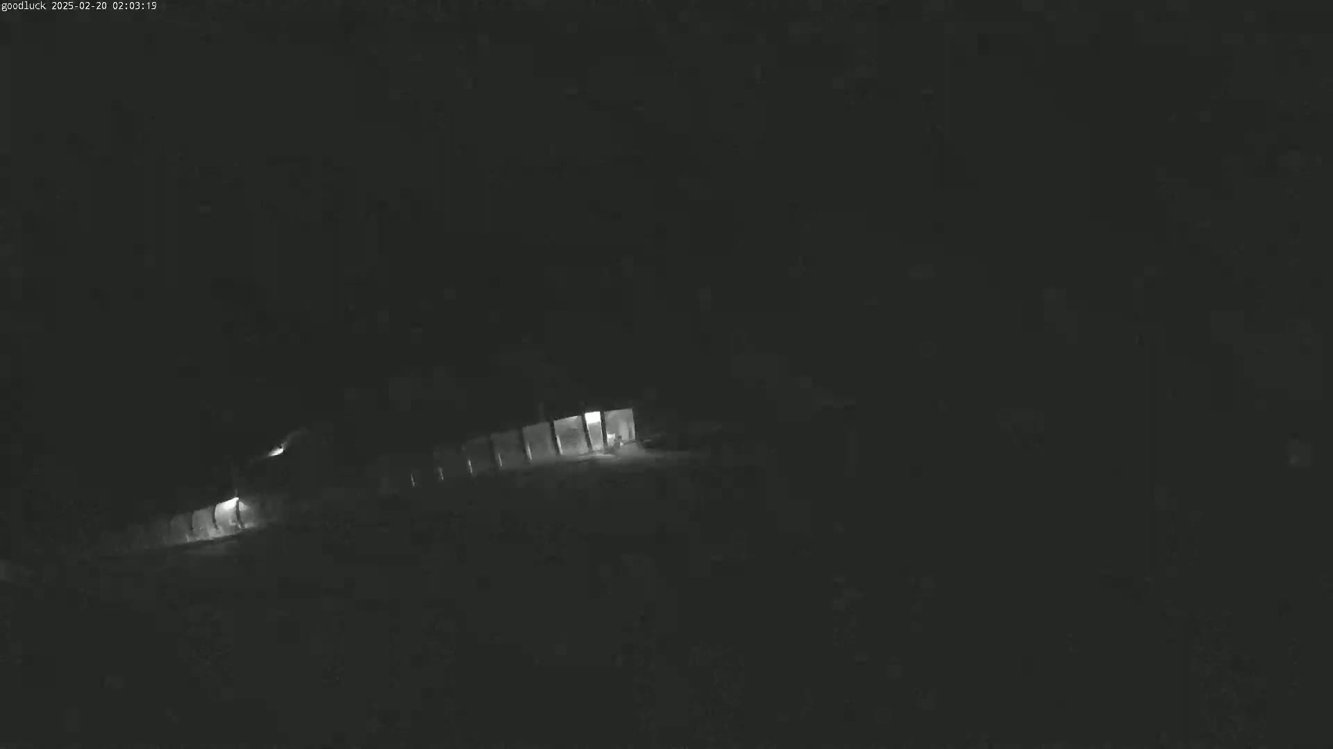 A dimly lit building is visible at night under dark conditions.