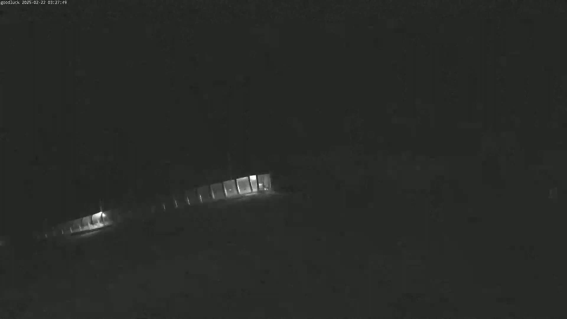 A dimly lit building is visible at night under dark, possibly cloudy conditions.