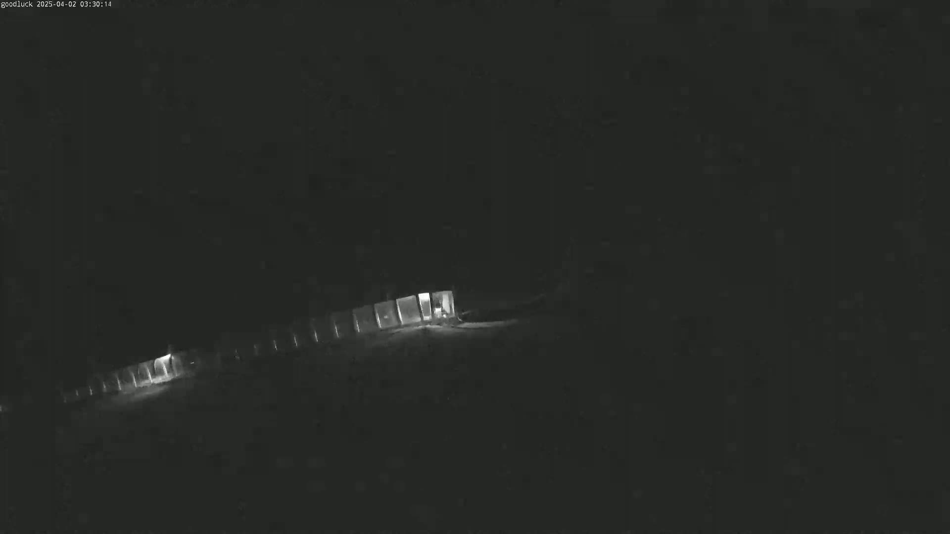 A long, dimly lit structure is visible at night.