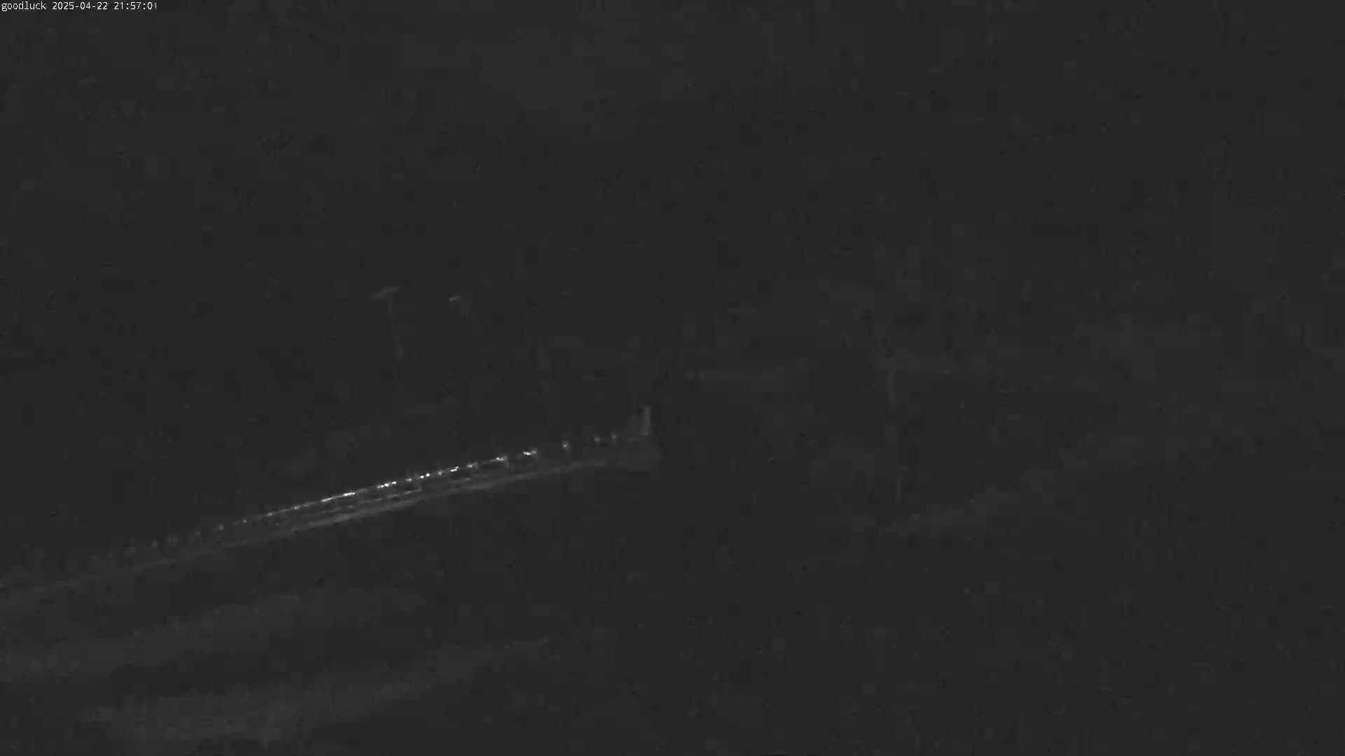 A low-light image shows a dimly lit roadway at night.